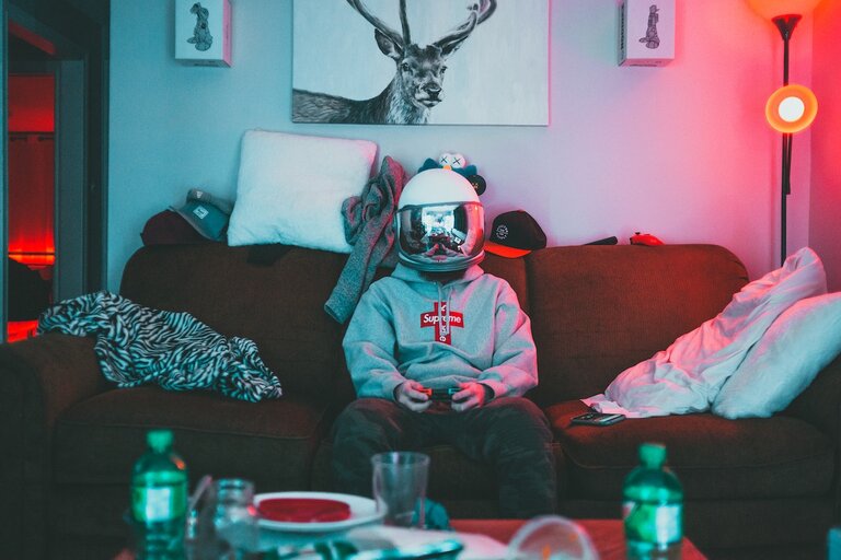 Person wearing a helmet sits on a sofa